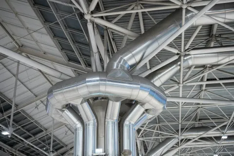 Close-up of metallic pipes and structures in an industrial setting showcasing modern architecture.