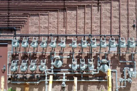 A row of gas meters on a brick wall showcasing utility infrastructure.