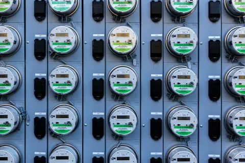 Rows of electricity meters displaying usage readings on a wall.