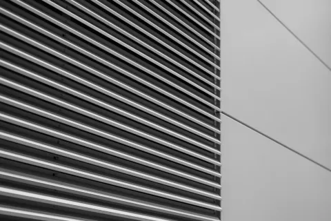 Close-up view of sleek, modern metal slats on a building facade in black and white.