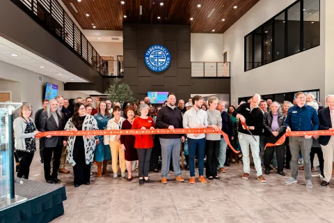 Group of people gathered for a ribbon-cutting ceremony inside a modern church lobby with Tabernacle Baptist Church signage.