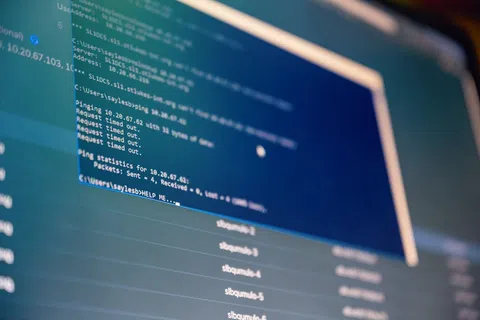 Close-up of computer screen showing network ping commands and timeout messages in a command prompt window.