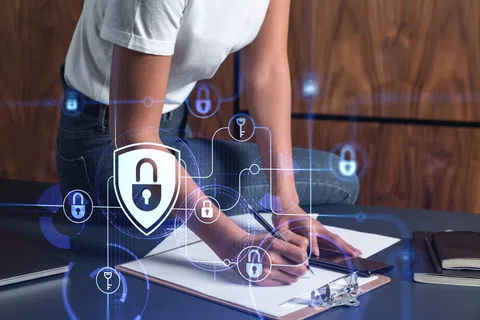 Person writing on clipboard with digital security and lock icons overlaid representing data protection concept.