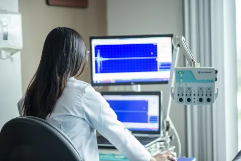 Doctor working at a computer in an exam room.
