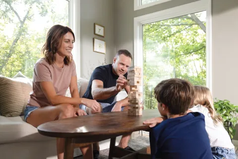 A family sitting in the living room playing a game without distractions thanks to noise reducing windows from Georgia's favorite windows installation contractor.