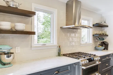 a kitchen with a stove and shelves