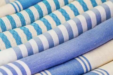 Close-up of rolled blue and white striped fabric patterns with various textures and shades.