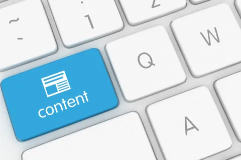 Blue content key on white keyboard symbolizing digital content creation and publishing.