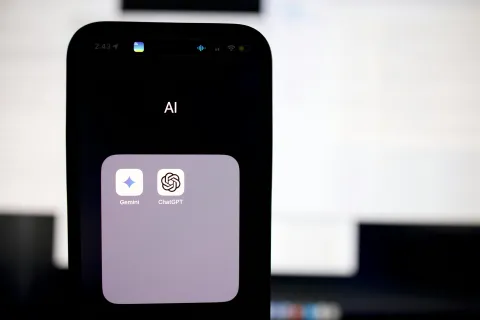 Smartphone screen showing a folder labeled AI with Gemini and ChatGPT apps used for integrating AI in business