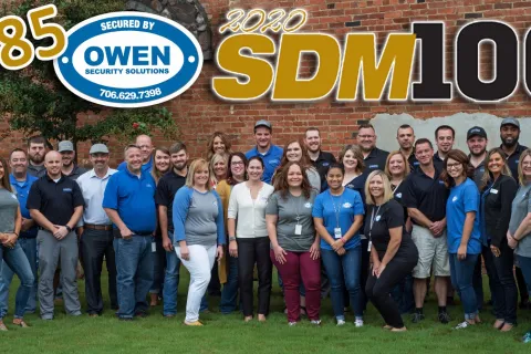 a group of people posing for a photo in front of a sign