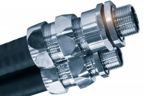 Close-up of hydraulic hoses with shiny metal connectors and threaded fittings on white background