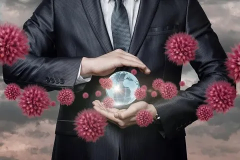 Businessman holding a glowing globe surrounded by 3D red virus particles representing global pandemic impact.