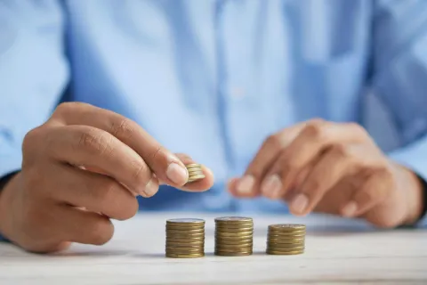a few hands holding coins