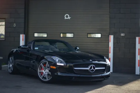 a black car parked in front of a garage
