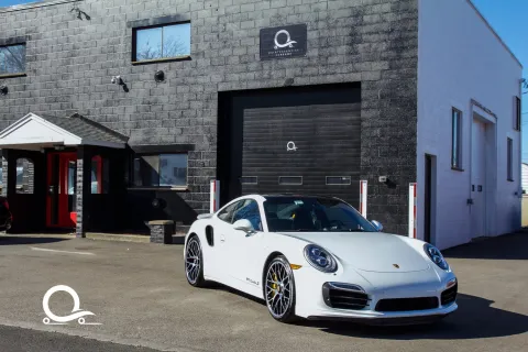a white sports car parked in front of a building
