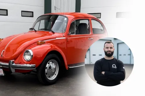 a man standing next to a red car