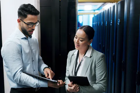 IT professionals discussing data server maintenance in a modern data center with server racks in the background