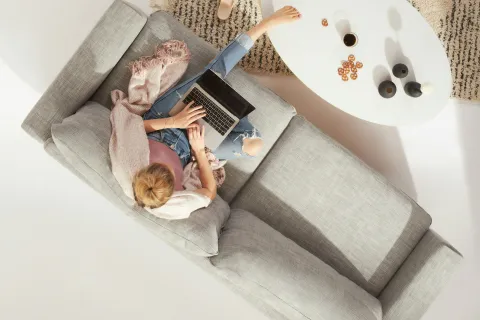 a person lying on a bed with a laptop