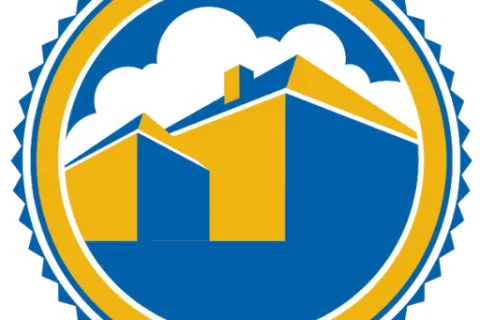 Circular emblem with stylized yellow and blue house shapes inside against a white cloud background