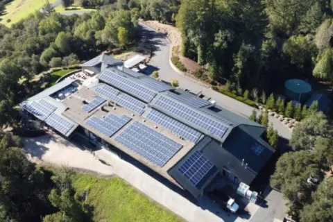 a building with a pool and trees around it
