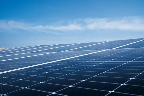 Close-up of solar panels under a bright blue sky capturing renewable energy from sunlight.
