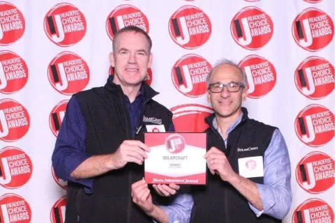 a couple of men holding a trophy