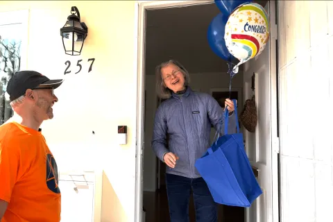 a man and a woman holding a blue bag
