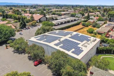 a building with a parking lot and trees around it