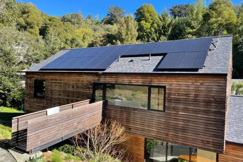 a house with a deck and trees in the back