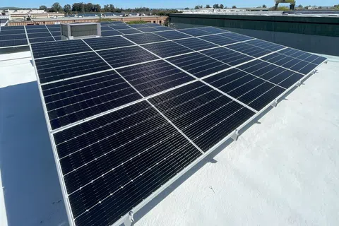 Aerial view of solar panels on a flat roof, harnessing solar energy in an urban setting.