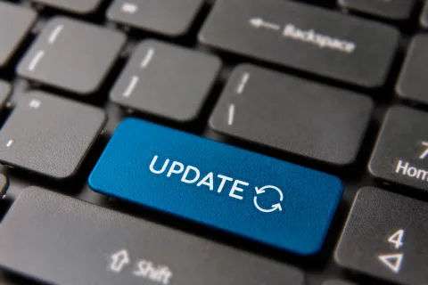 A close-up of a keyboard's blue 'UPDATE' key, symbolizing software and system updates.