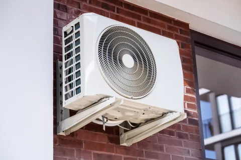 a fan on a brick building