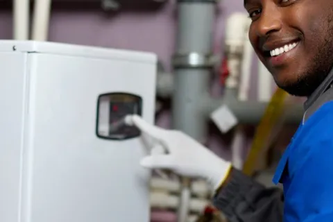 a man smiling and holding a white machine