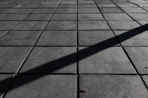 a shadow of a person on a brick surface