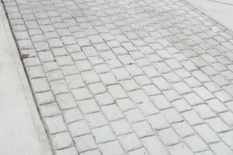 a cobblestone road with a sidewalk and a sidewalk