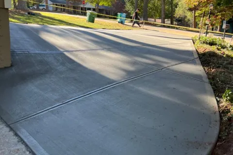 a person riding a bicycle on a road with trees on either side