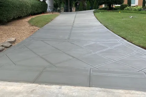 a paved walkway with grass and trees