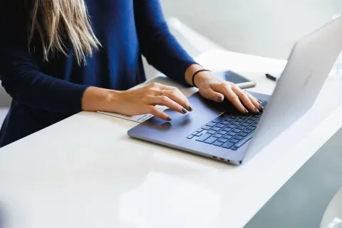 a woman typing on a laptop