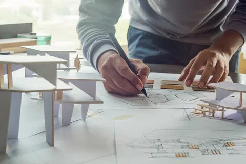 Architect working on a project with a black pen.
