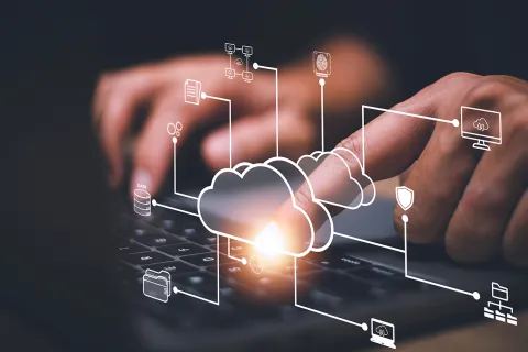 Hand interacting with keyboard with digital cloud computing and data security icons overlayed..