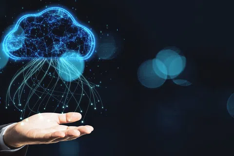 Hand holding glowing digital cloud icon with connecting lines representing cloud computing and data flow.