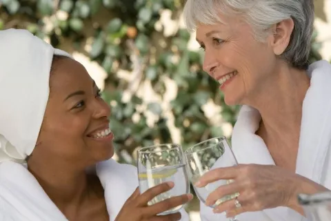 two women holding drink glasses