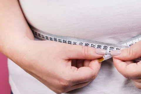 a close-up of a person holding a tape measure