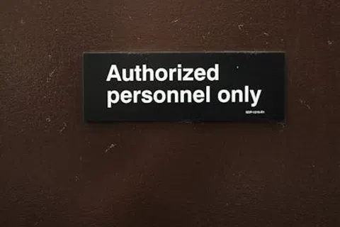 Black sign on brown door reading Authorized personnel only in white text restricting access.
