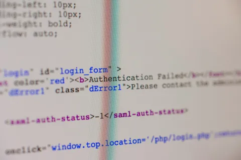 Close-up of computer screen showing HTML code with multi-factor authentication fail error message
