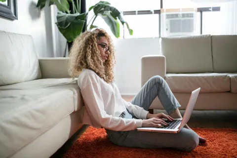 a person sitting on a couch with a laptop