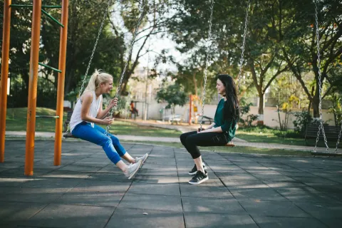 a couple of women on a swing