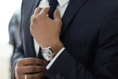 a man in a suit and tie holding his hands together