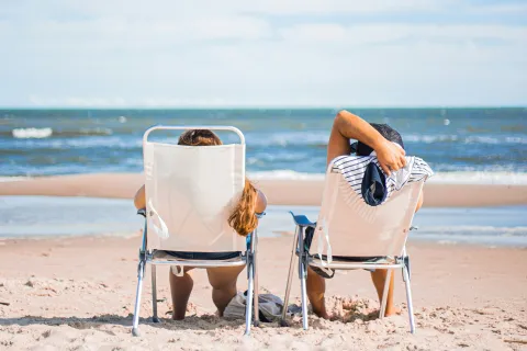 a pair of chairs on a beach