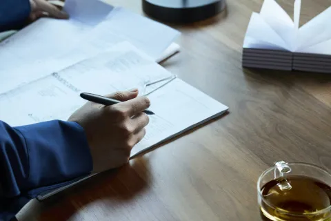 a person writing on a piece of paper